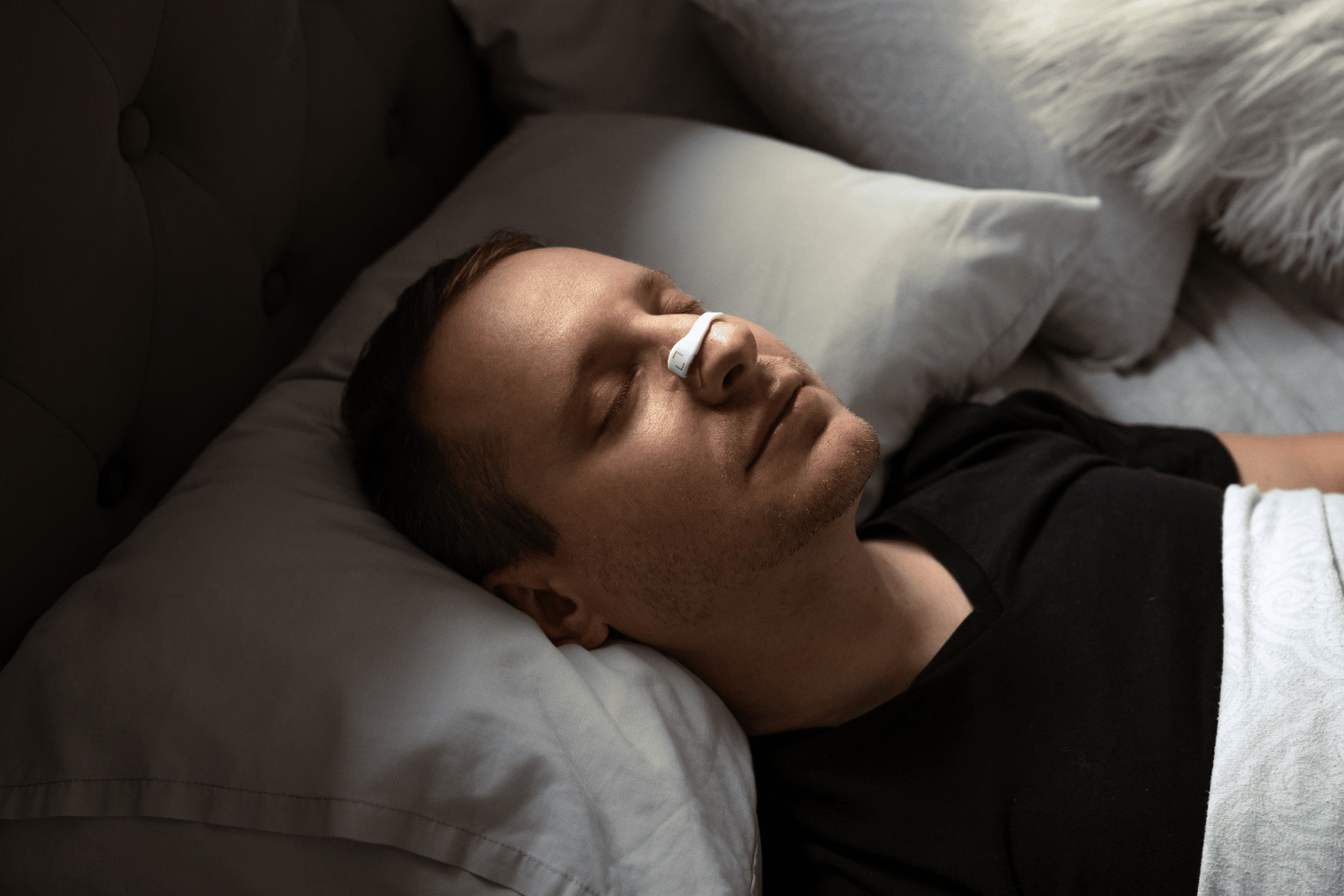 man wearing nasal strips while sleeping