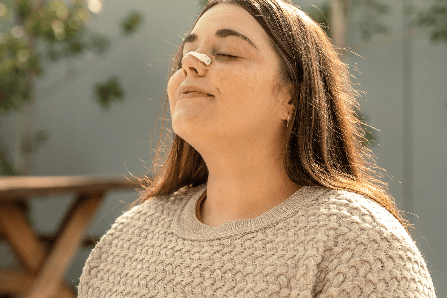 woman wearing nasal strips for breathing and nasal relief  